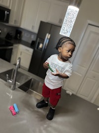 a young boy standing on a kitchen counter